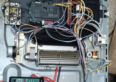 Técnico de Repara Palencia midiendo con pinza amperimétrica el consumo de un horno desmontado durante la reparación